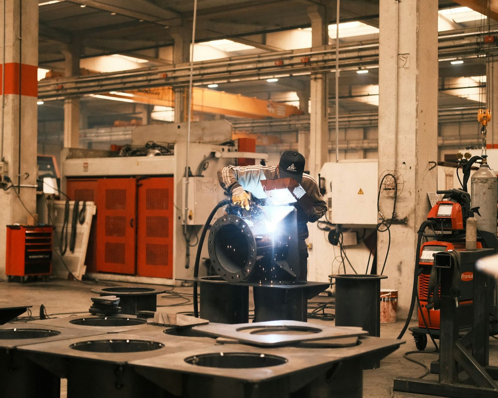 Welder working on a steel fabrication in an engineering workshop, the kind of plant-heavy business where a buyer must choose between buying the shares or the assets