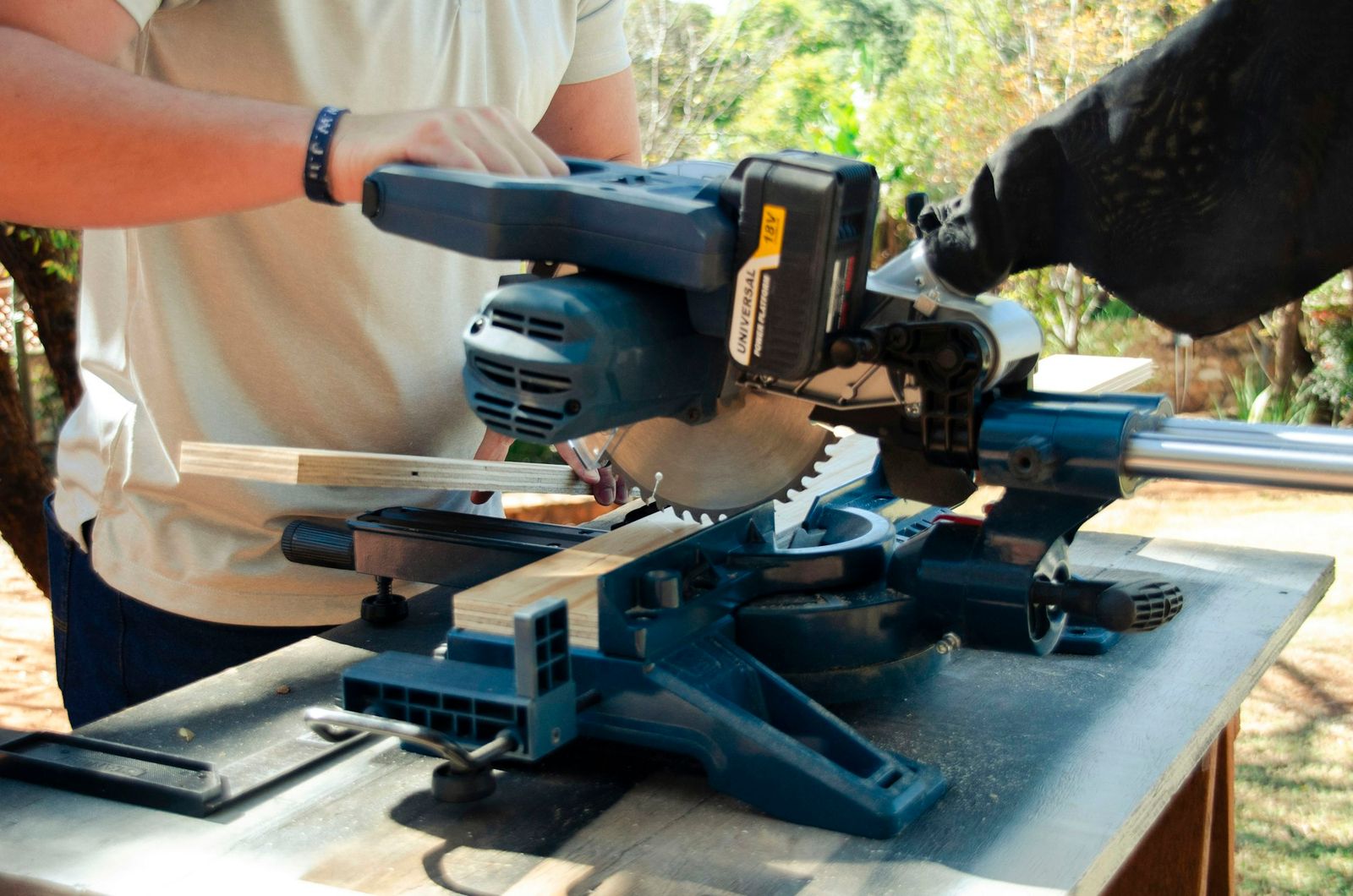Carpenter cutting timber on a table saw in a joinery workshop